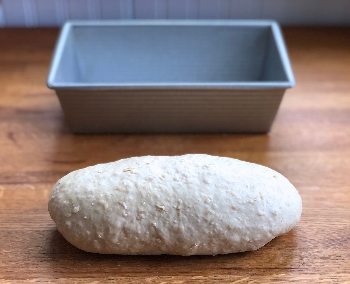 Oatmeal bread dough shaped into a log