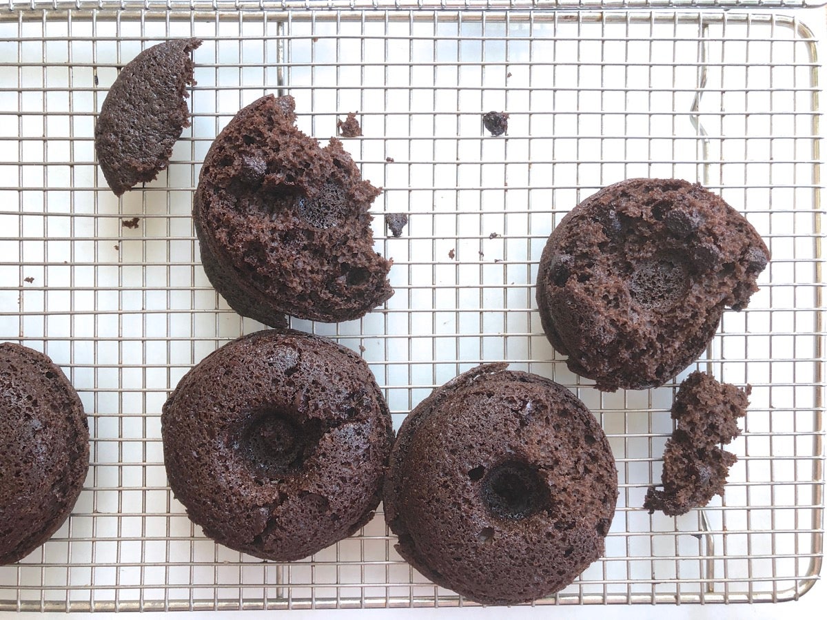 Crumbled chocolate doughnuts on a cooling rack.