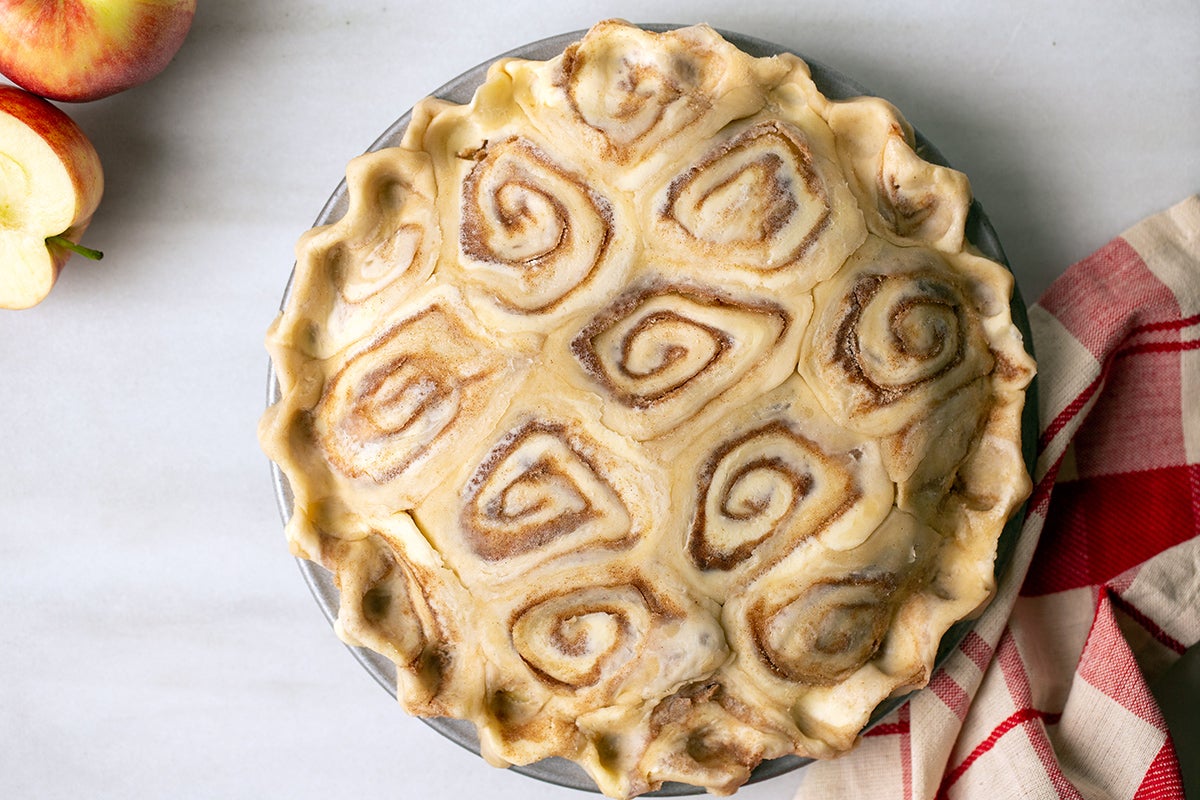 An unbaked apple pie with a cinnamon bun pie crust