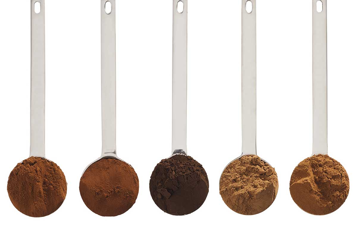 Five tablespoons full of cocoa powder lined up, each a different shade of brown