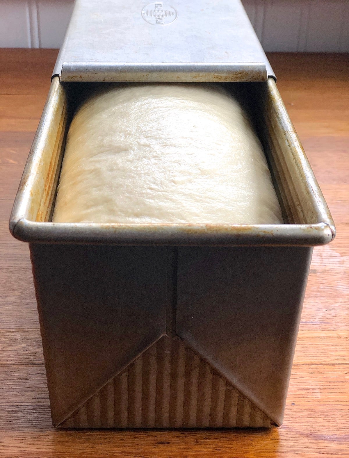 Risen dough in a loaf pan, ready to bake.