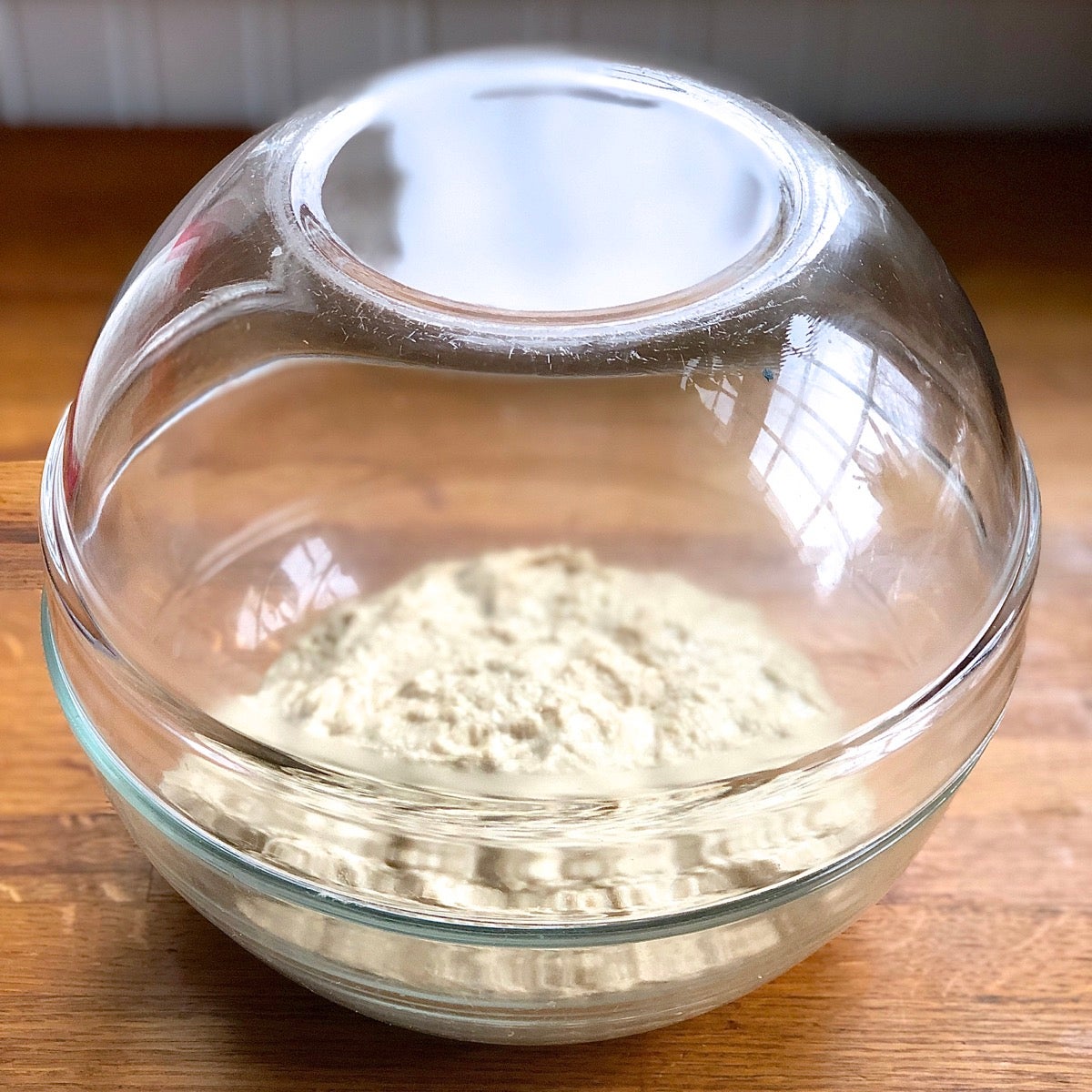 A preferment for Greek Olive and Onion Bread in a glass bowl, ready to rise overnight