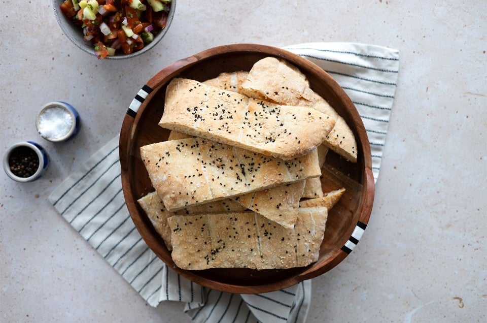 A bowl of Afghan naan topped with black and white sesame seeds - select to zoom