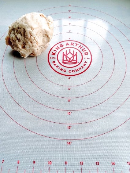 Ball of pie pastry on a clean silicone rolling mat showing mat's markings.