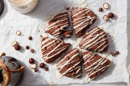 Chocolate malted scones drizzles with glaze and surrounded by malted milk balls
