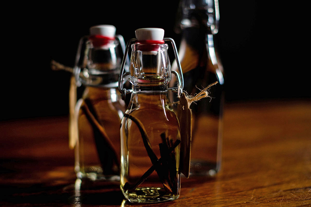 Three bottles of homemade vanilla extract, ready to infuse, placed in a cool and dark place.