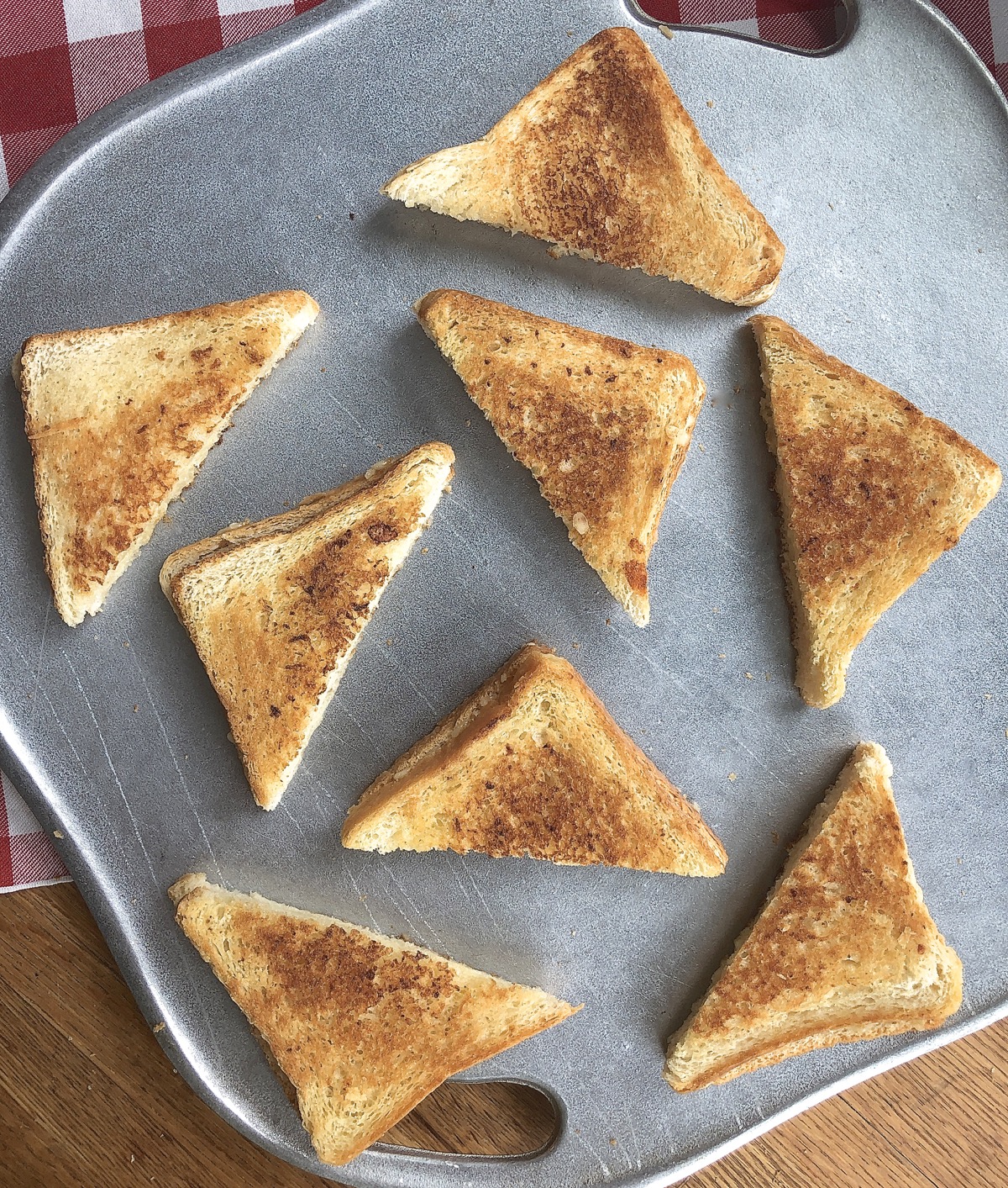 Grilled cheese sandwiches cut in triangles, arranged on a serving plate