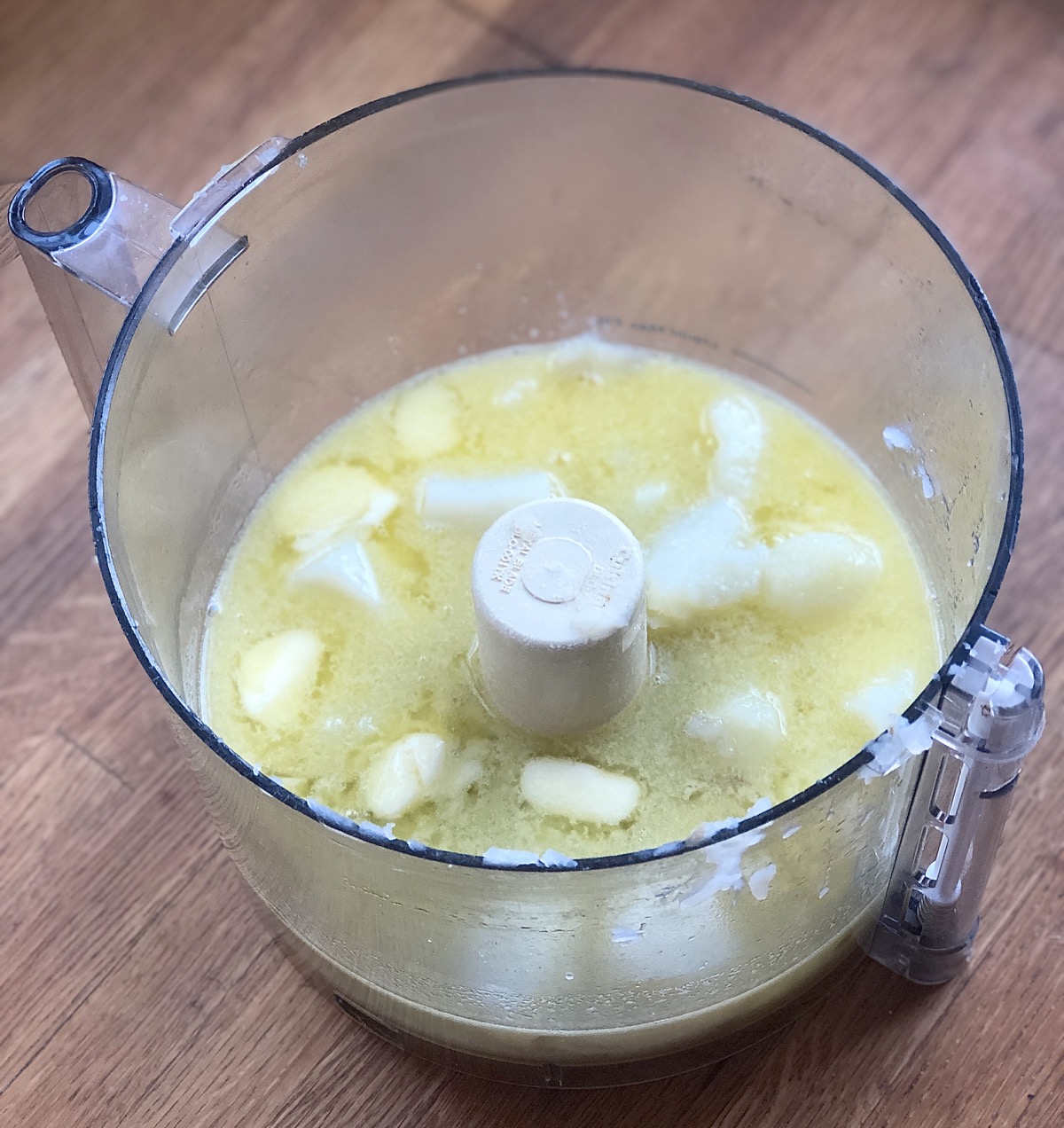 Potato chunks, hot water, butter, sugar, and salt in the bowl of a food processor.
