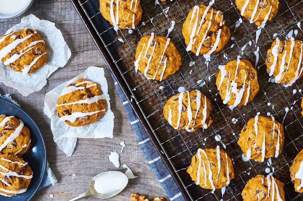 Pumpkin Chocolate Chip Cookies on a cooling rack drizzled with white sugar glaze.