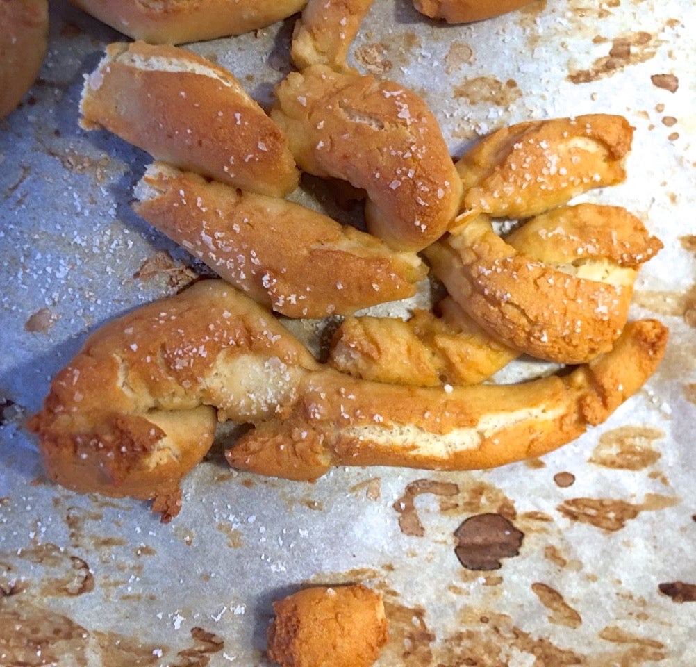 Broken up soft and chewy gluten-free pretzels on a baking sheet.