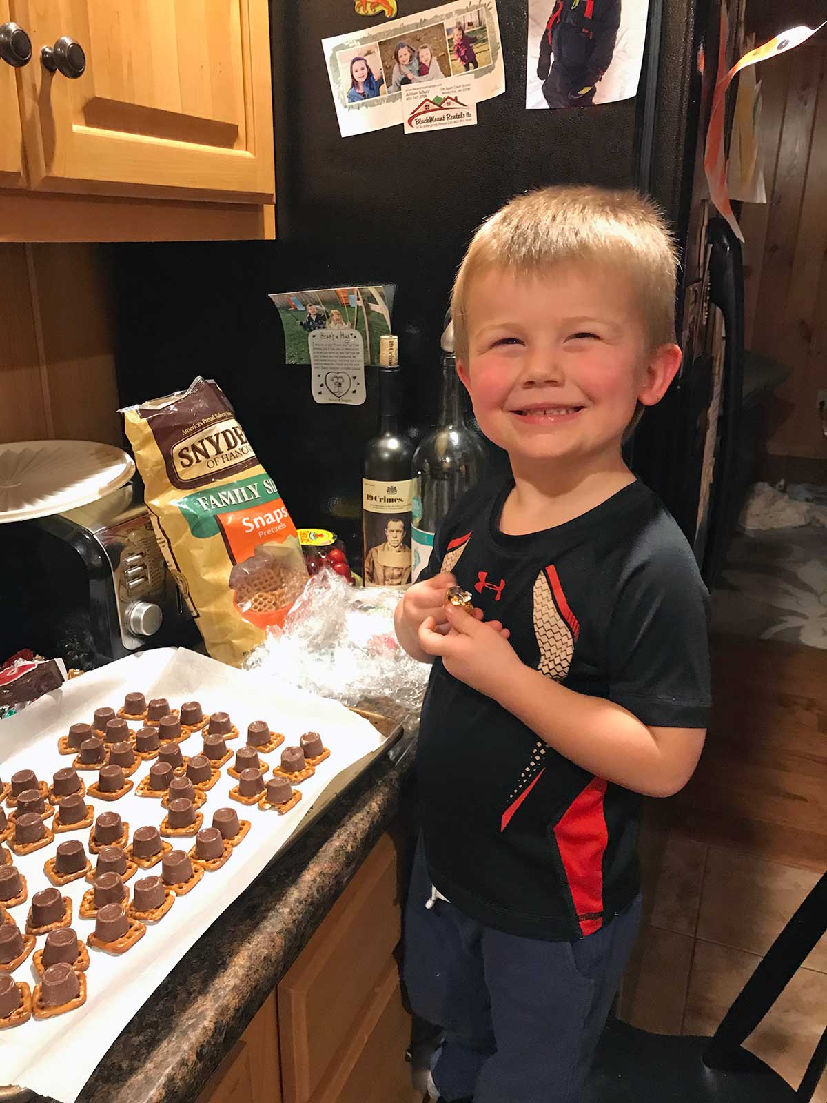 A small child making no-bake energy bites at home, smiling
