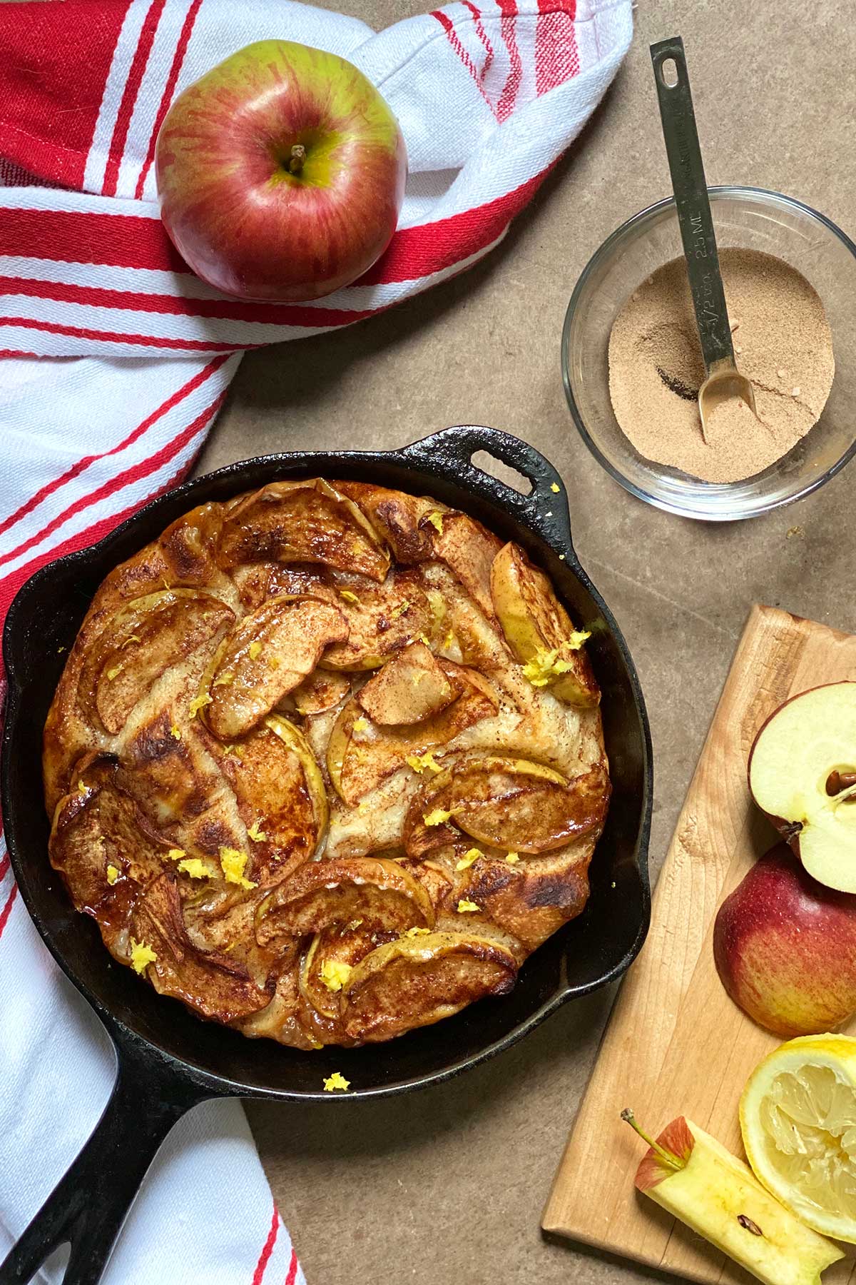 A cast iron pizza topped with sliced apples, cinnamon-sugar, and brown butter