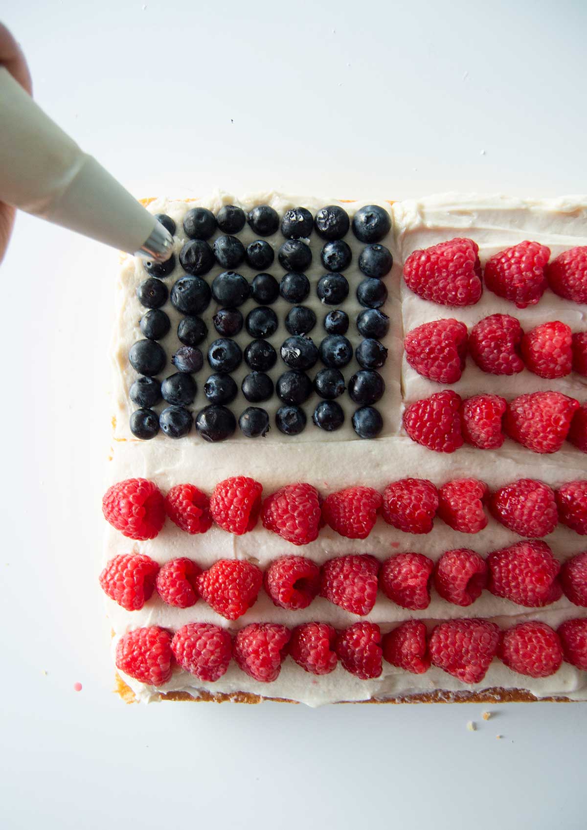 Hand piping stars on flag cake
