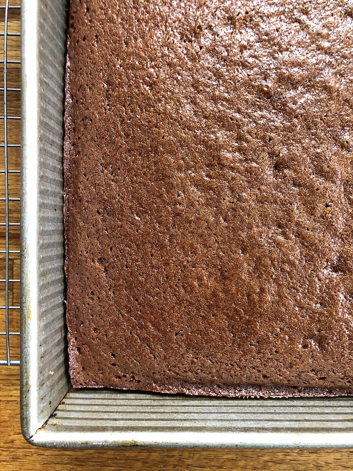 Baked gingerbread in a pan, edges just pulling away from the sides of the pan.