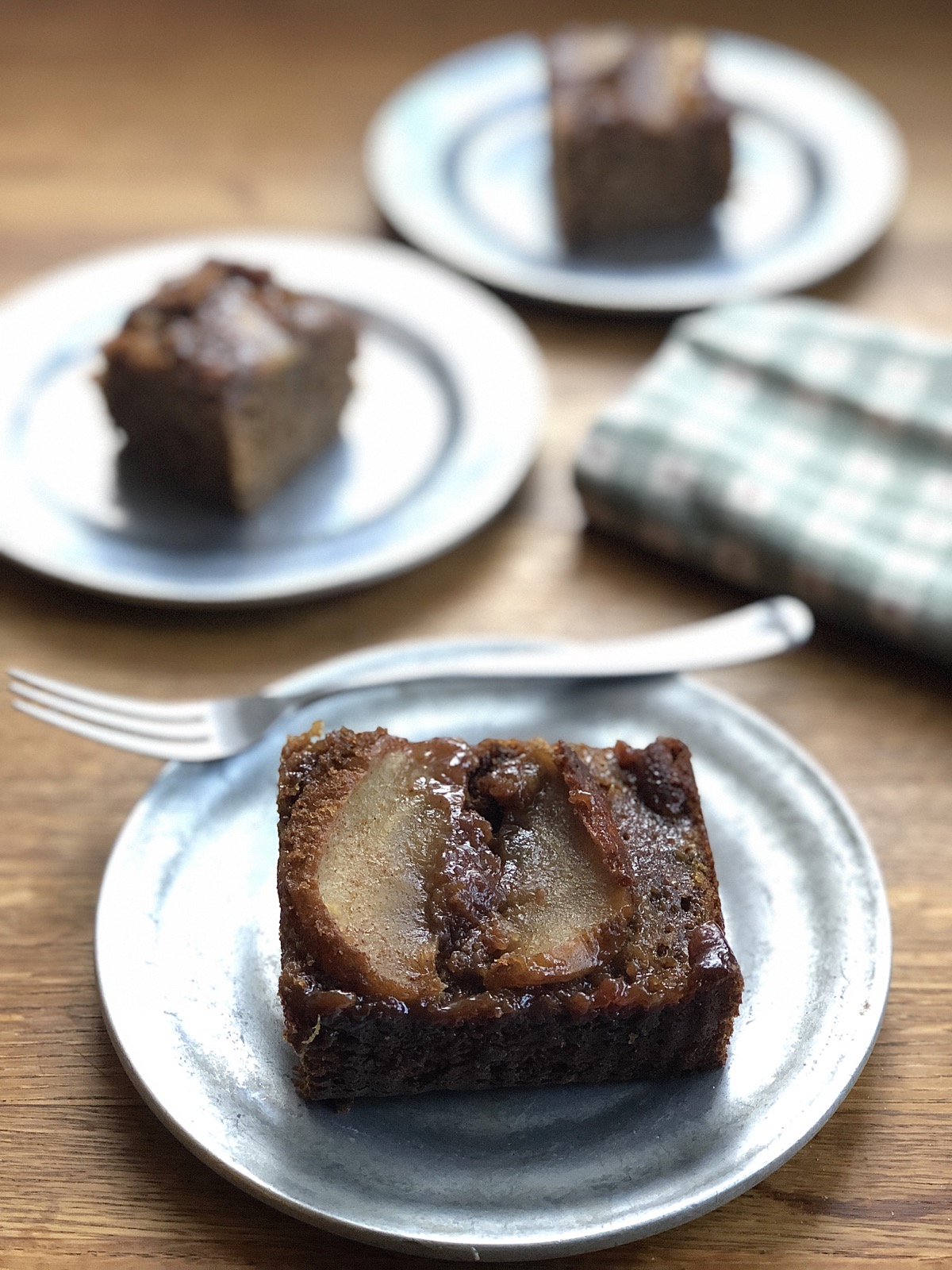 Square of apple upside-down gingerbread cake on a plate