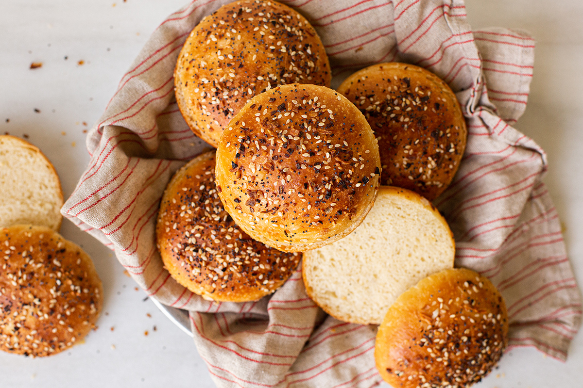 Homemade hamburger buns with Everything Bagel Topping, split and in a basket