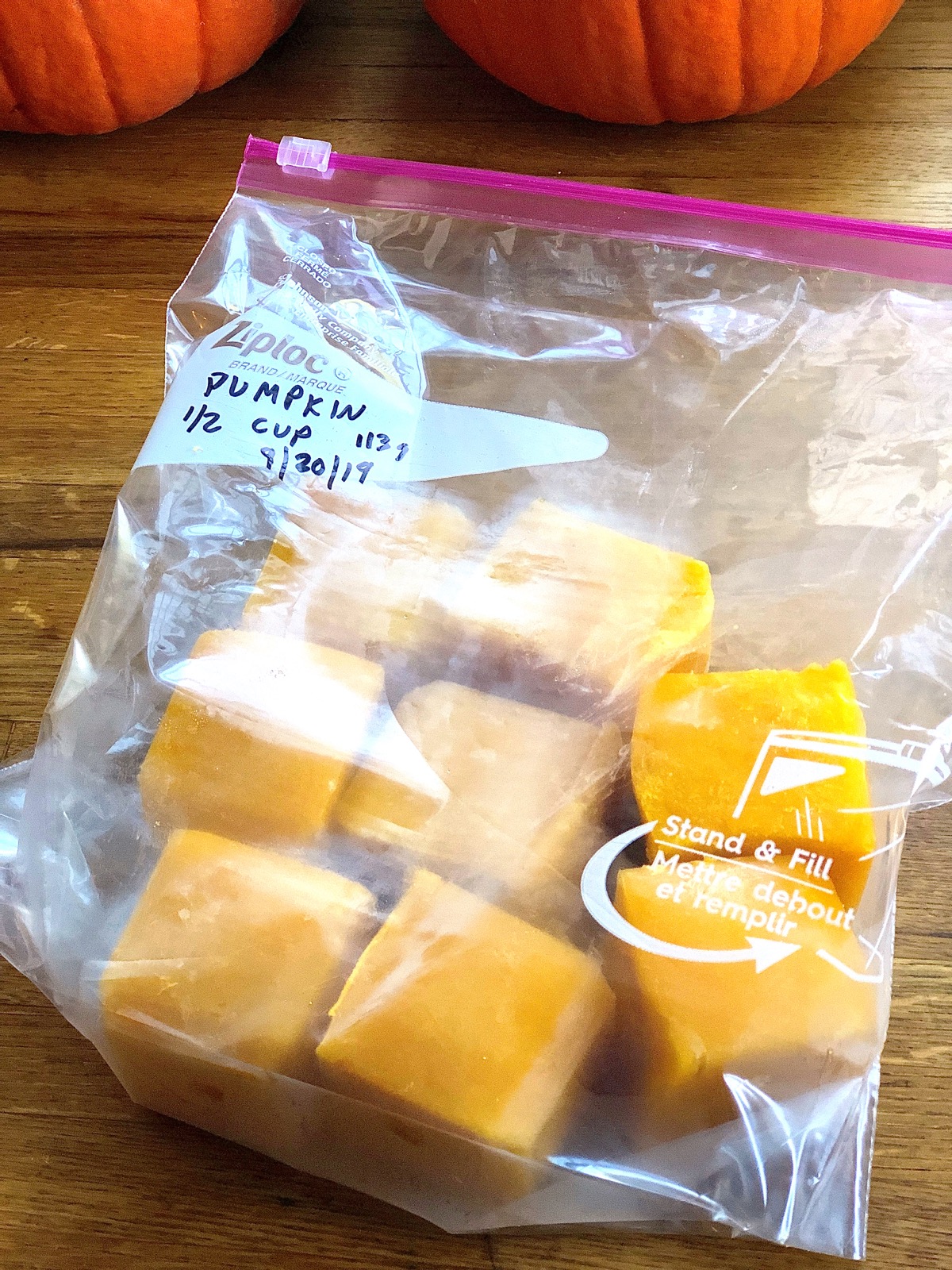 Homemade pumpkin purée frozen in cubes, placed in a labeled freezer bag