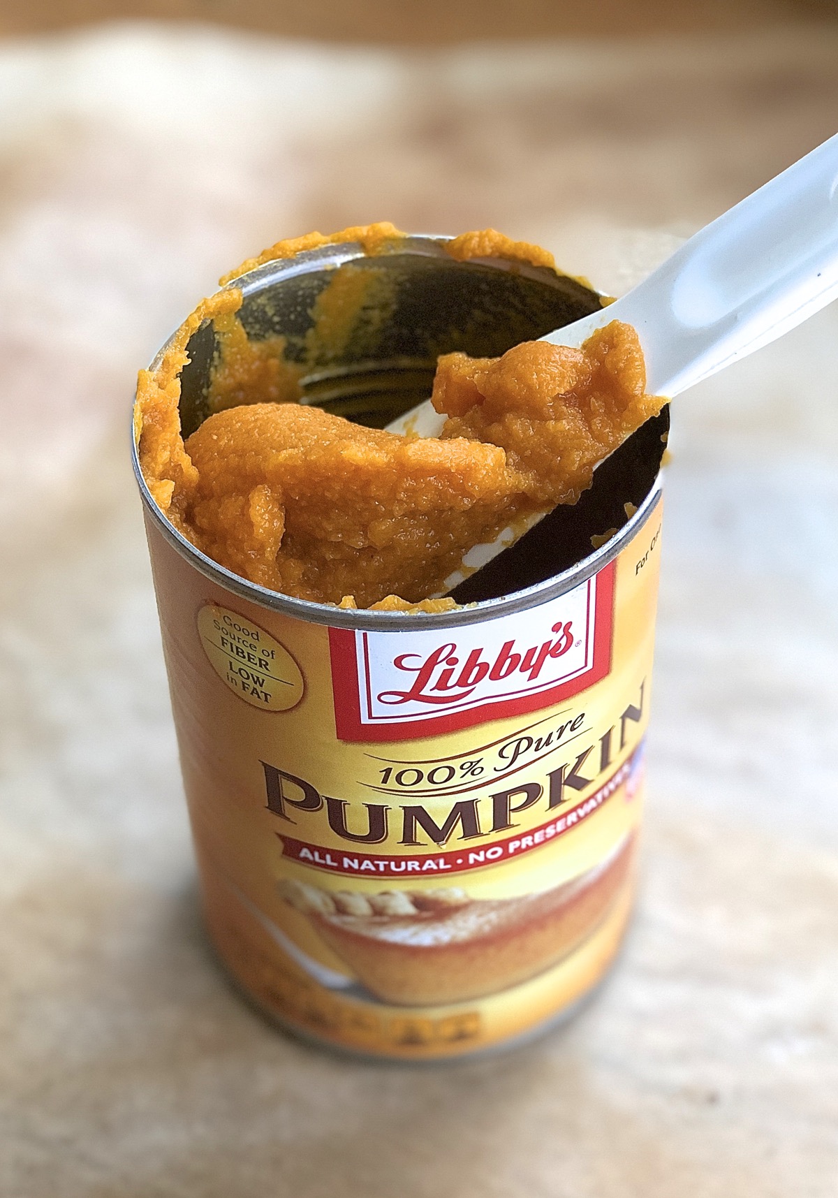 Pumpkin purée being spooned out of half-empty pumpkin can