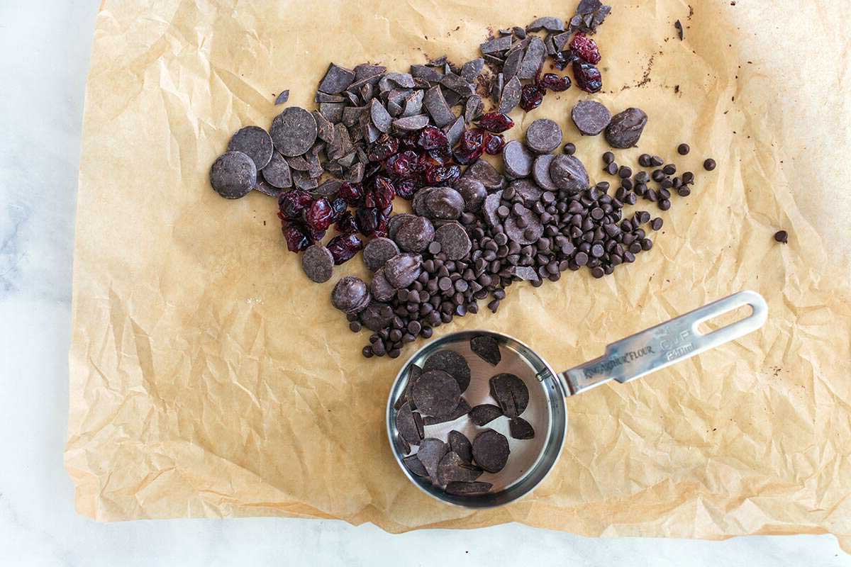 Different chocolates and dried fruit on parchment paper