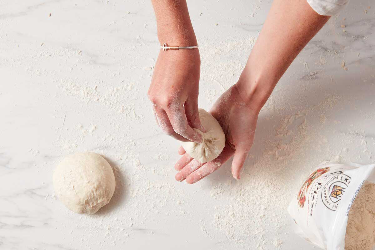 Hands cupping a shaped pouch of dough