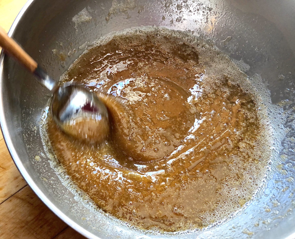 Butter and brown sugar for brown sugar frosting cooking in a saucepan.