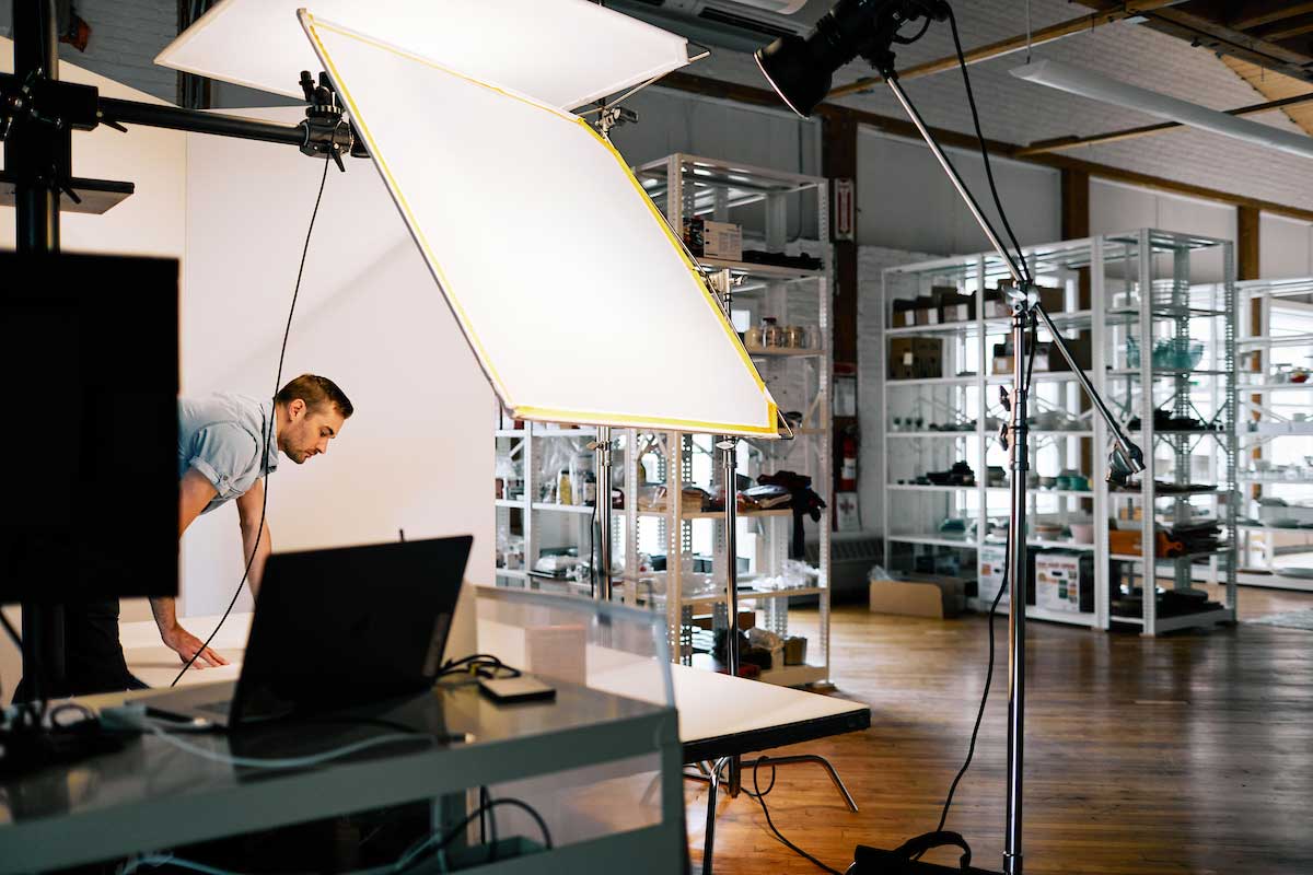 Photographer with photo and lighting equipment in studio 