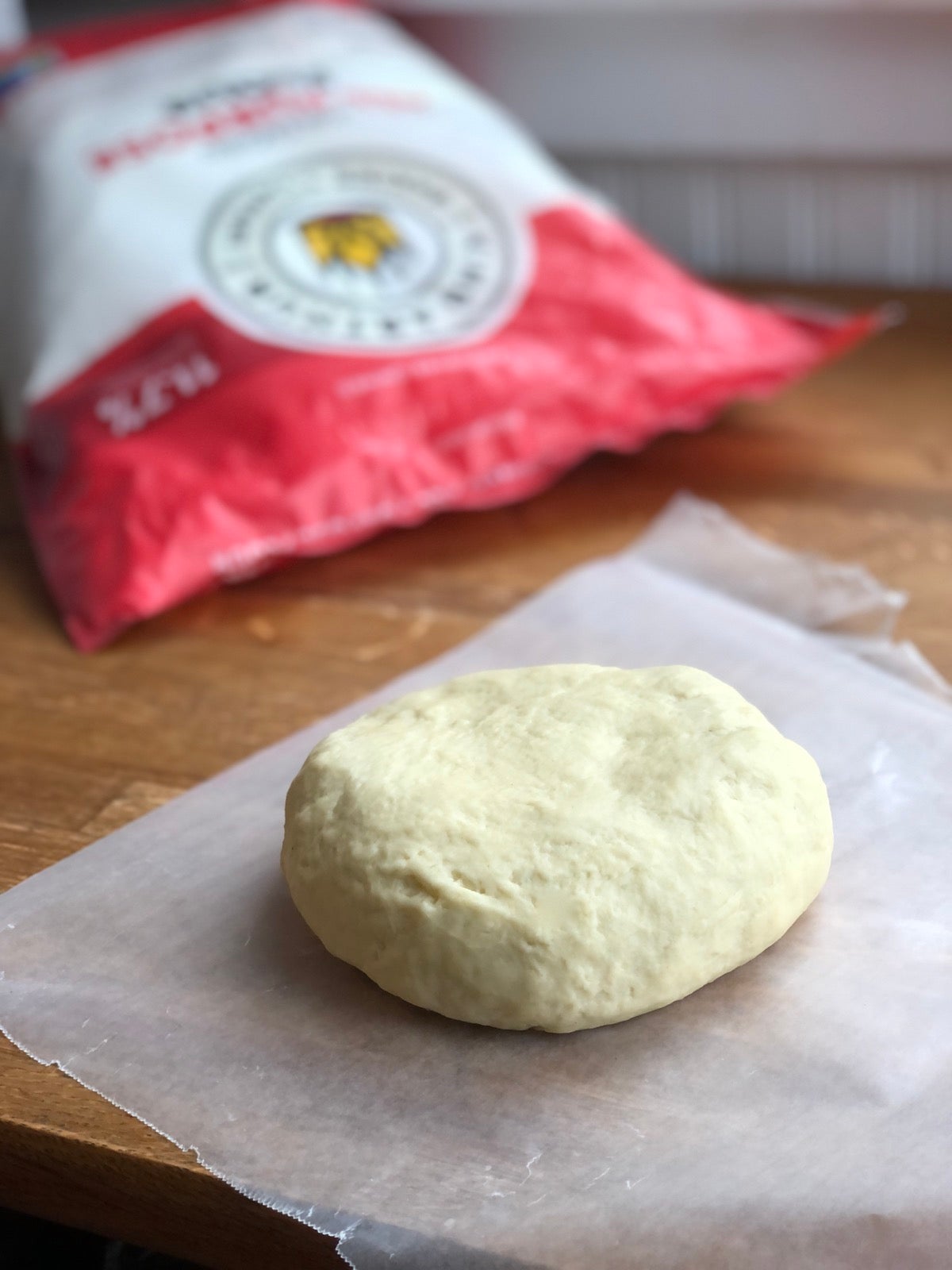 Pierogi dough flattened into a disc, ready to wrap and chill.