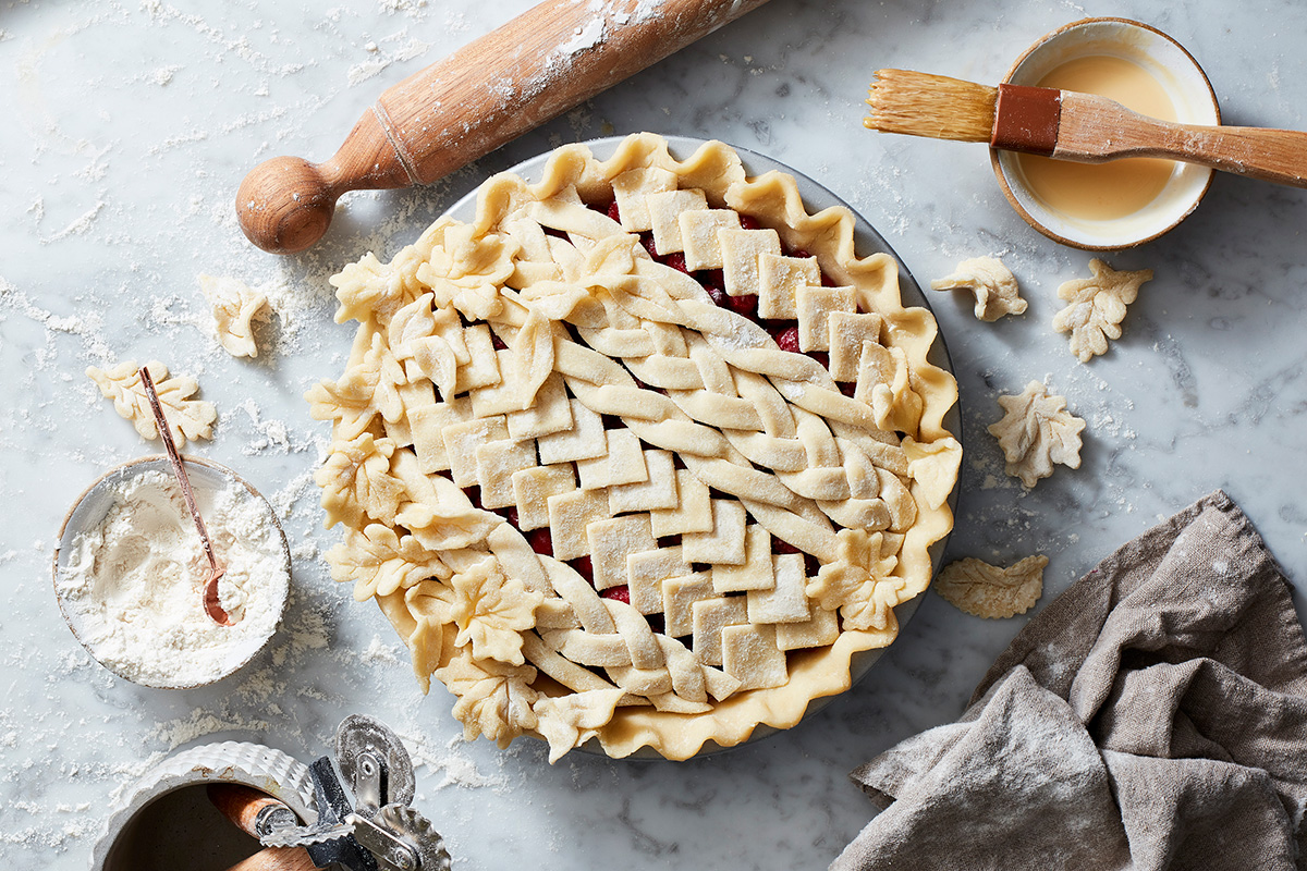 An unbaked, lattice-topped pie made with Rustic Milk Pie Dough