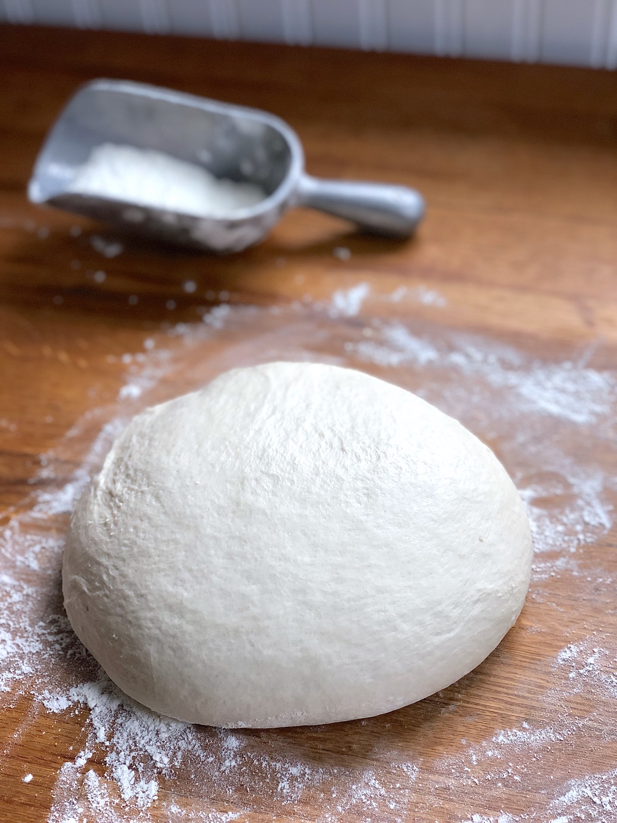 Fully kneaded dough for Rustic Sourdough Bread, resting on a floured board.