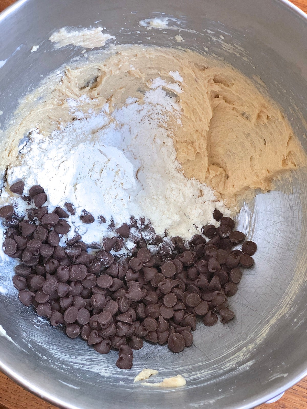 Miing flour and chocolate chips into the remaining dough for chocolate chip cookies.
