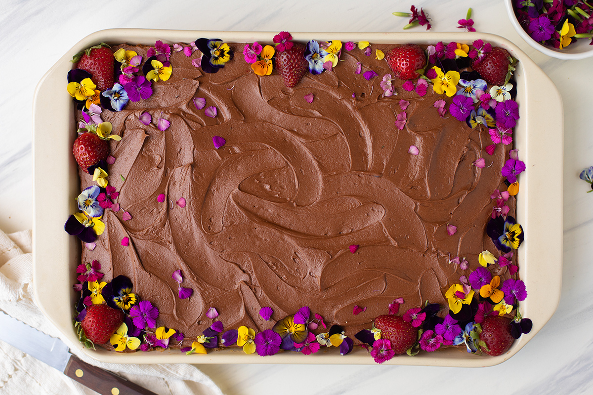 A Classic Birthday Cake baked as a sheet cake and decorated with edible flowers and strawberries