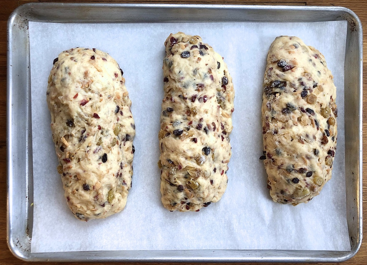 Three stollen on a baking sheet, risen and ready to bake.