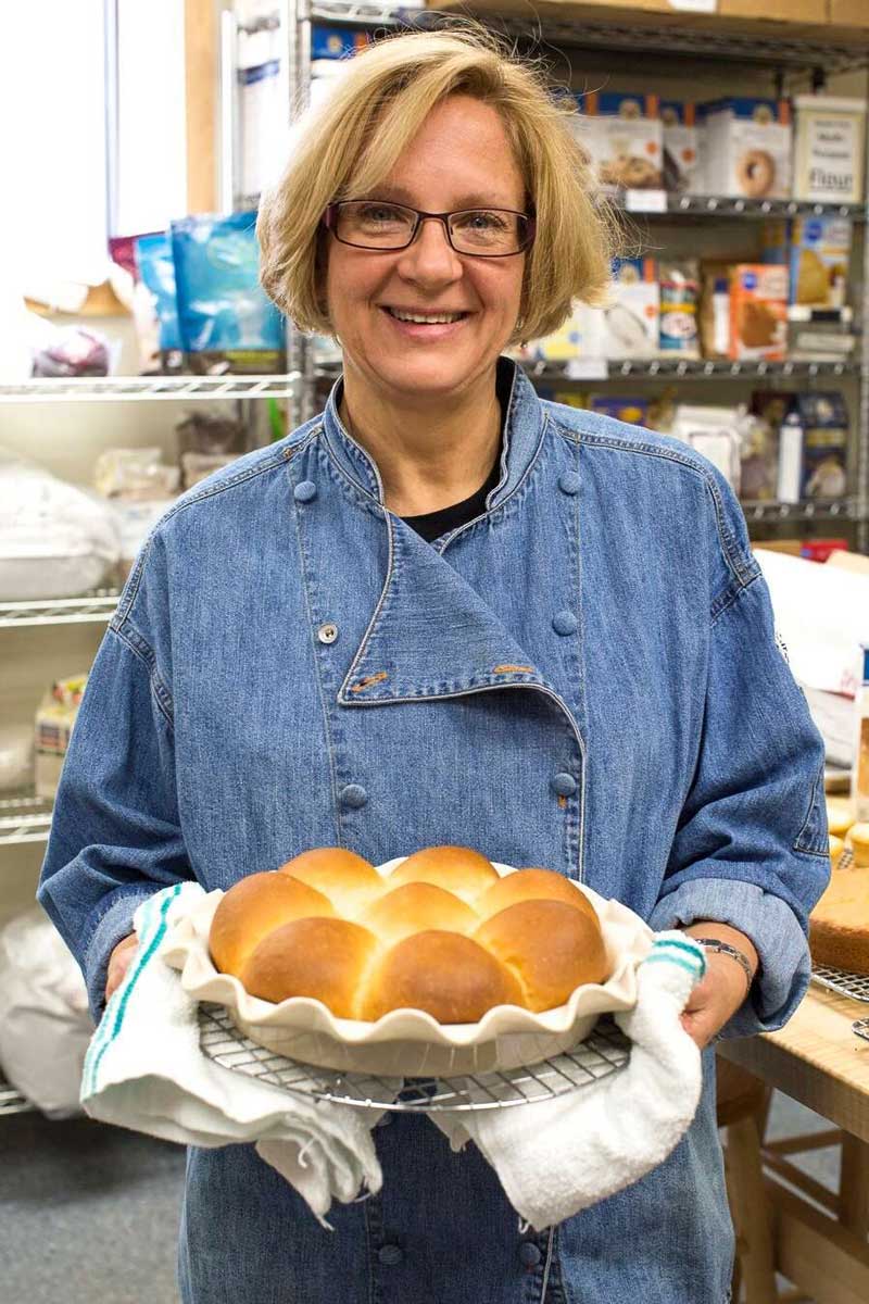 Sue Gray holding a pan of rolls