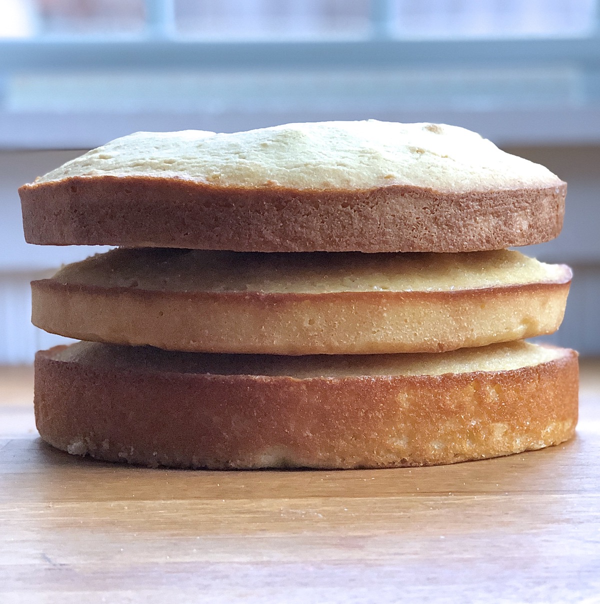 Three cake layers baked with three different sweeteners, stacked atop one another to show difference in rise