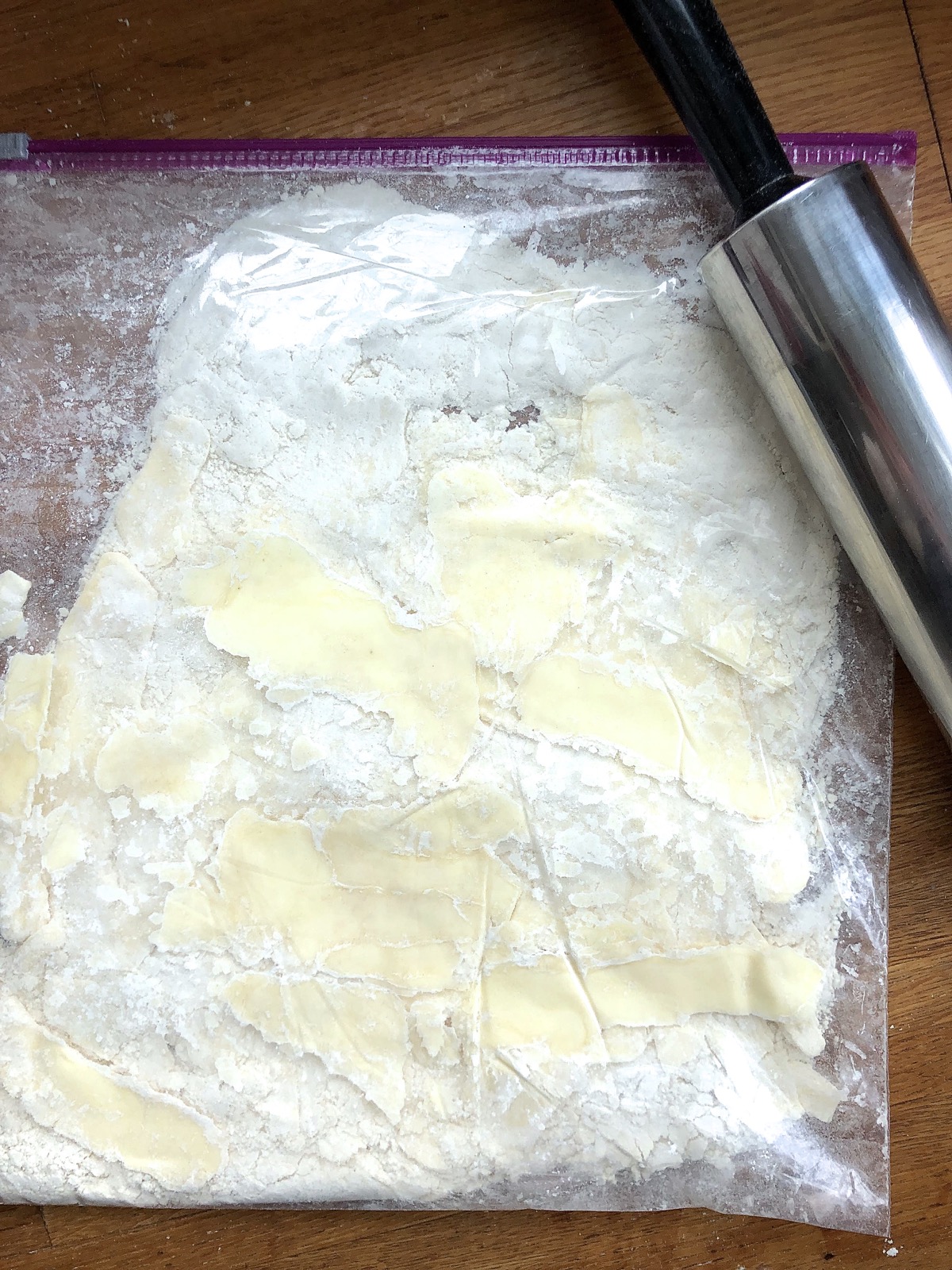Chunks of butter in flour inside a zip-top bag, smeared and stuck to the bag's inner surface.