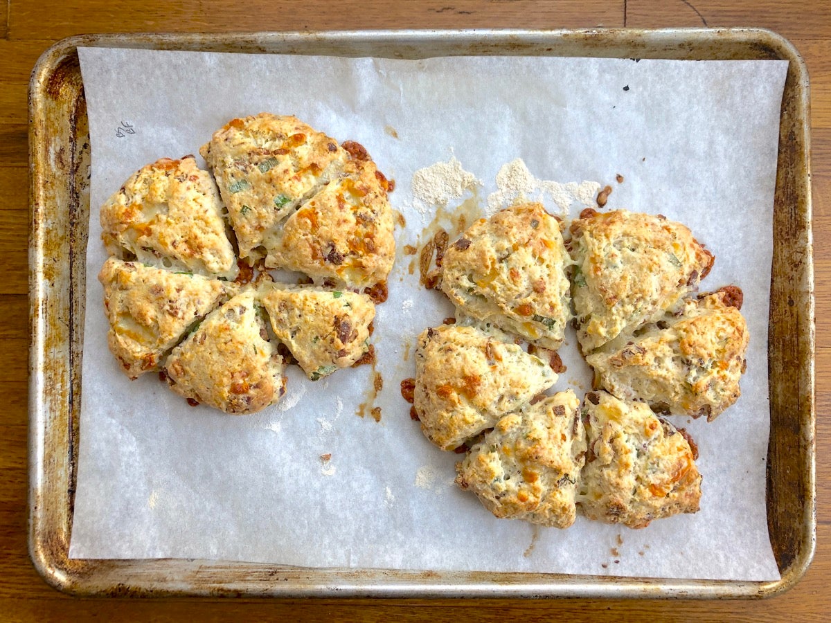 Baked scones, hot out of the oven, on a baking sheet.