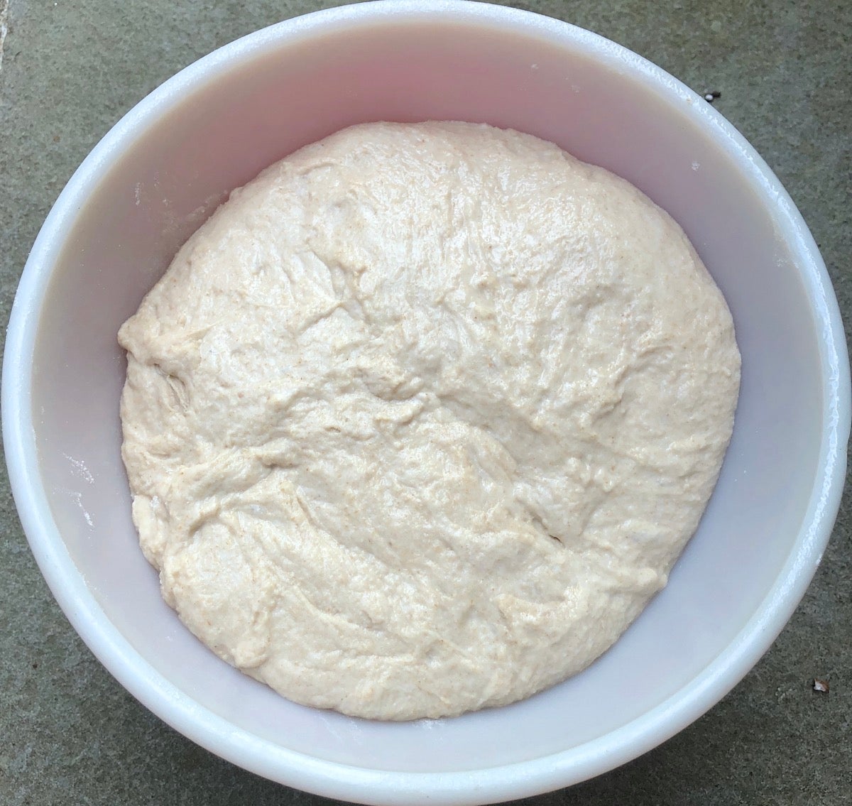 Dough in a red Pyrex bowl, ready to rise. 