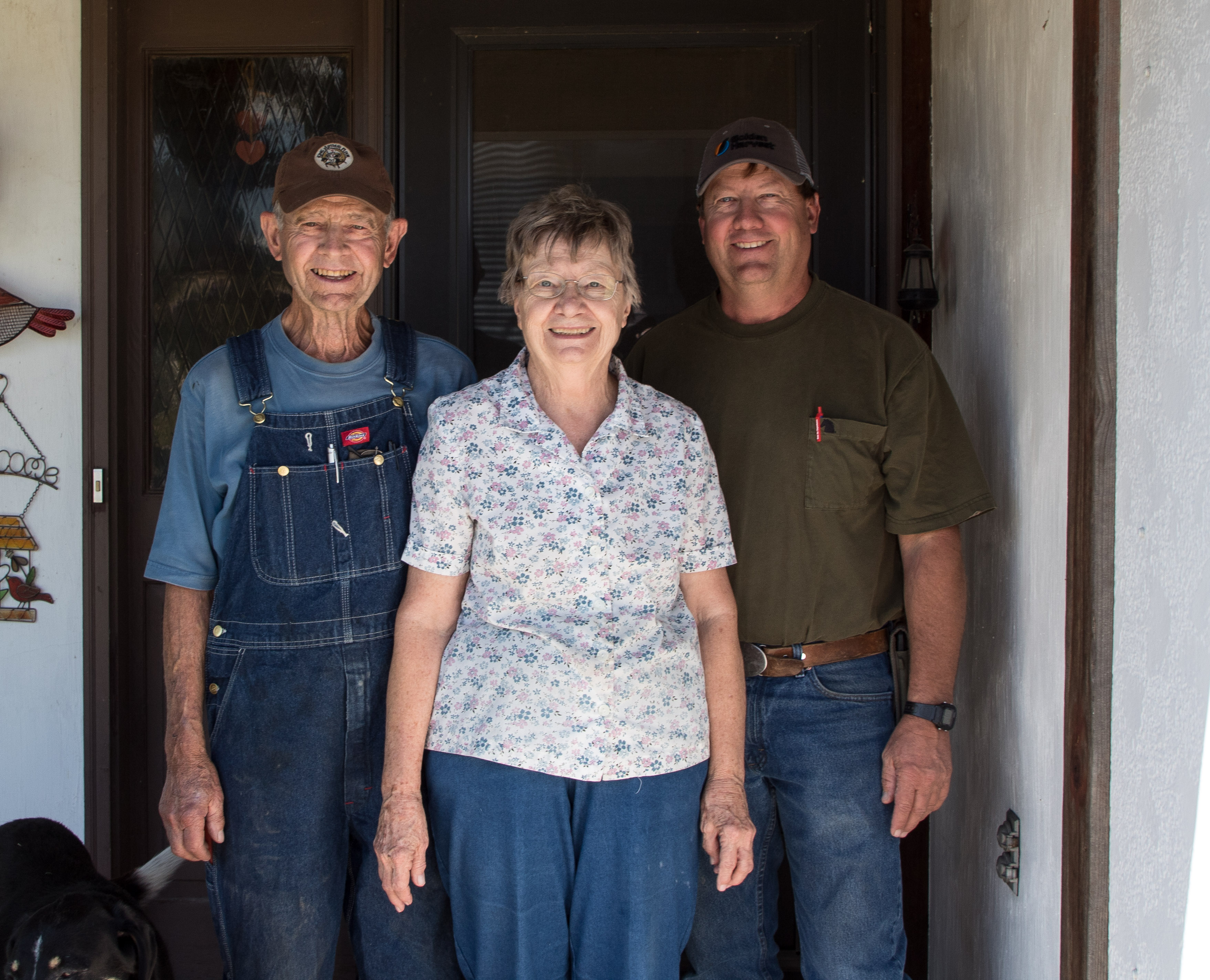 Bill, Wilma, and Carl Mai on their front porch