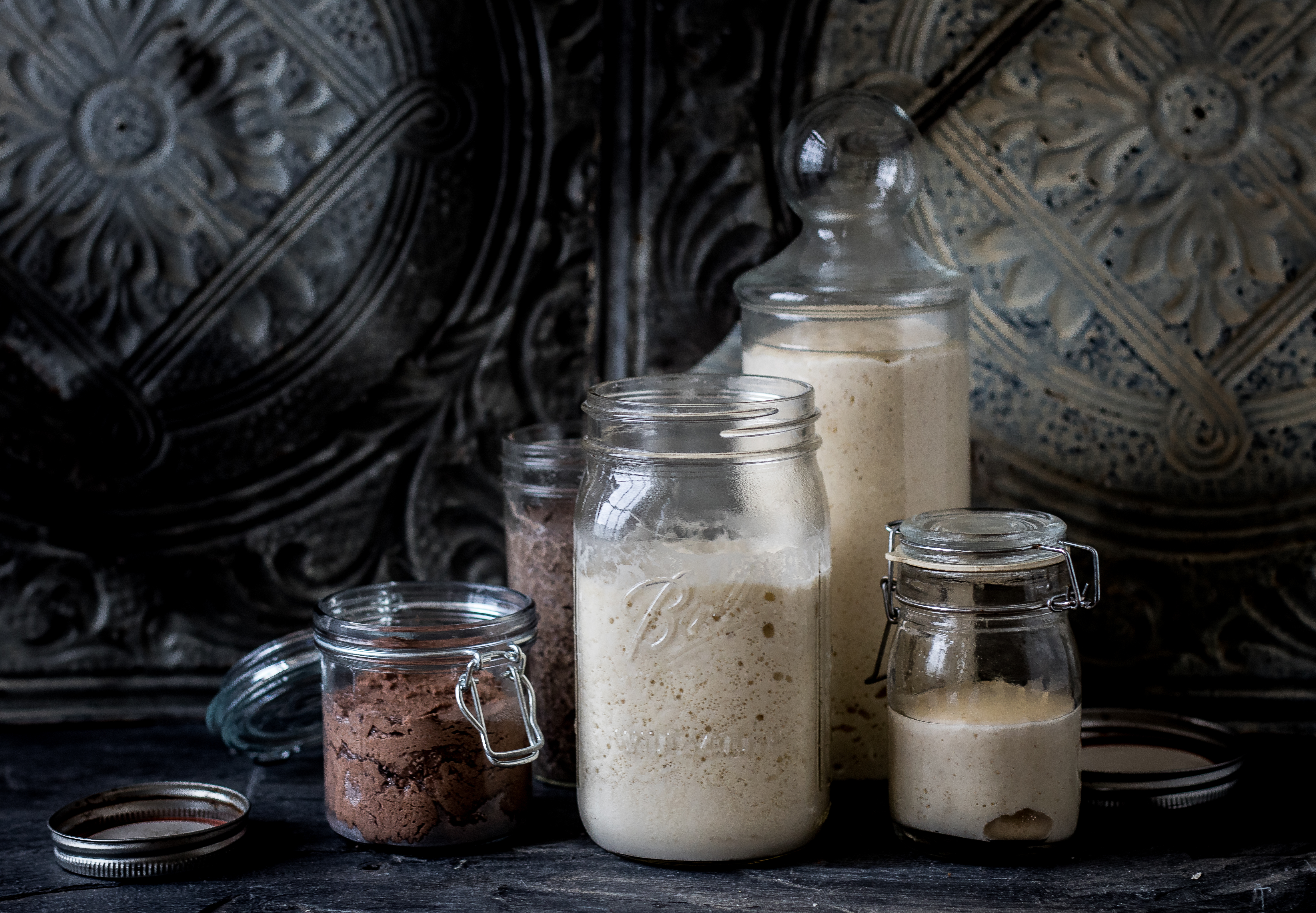 A series of preferments in jars on a table