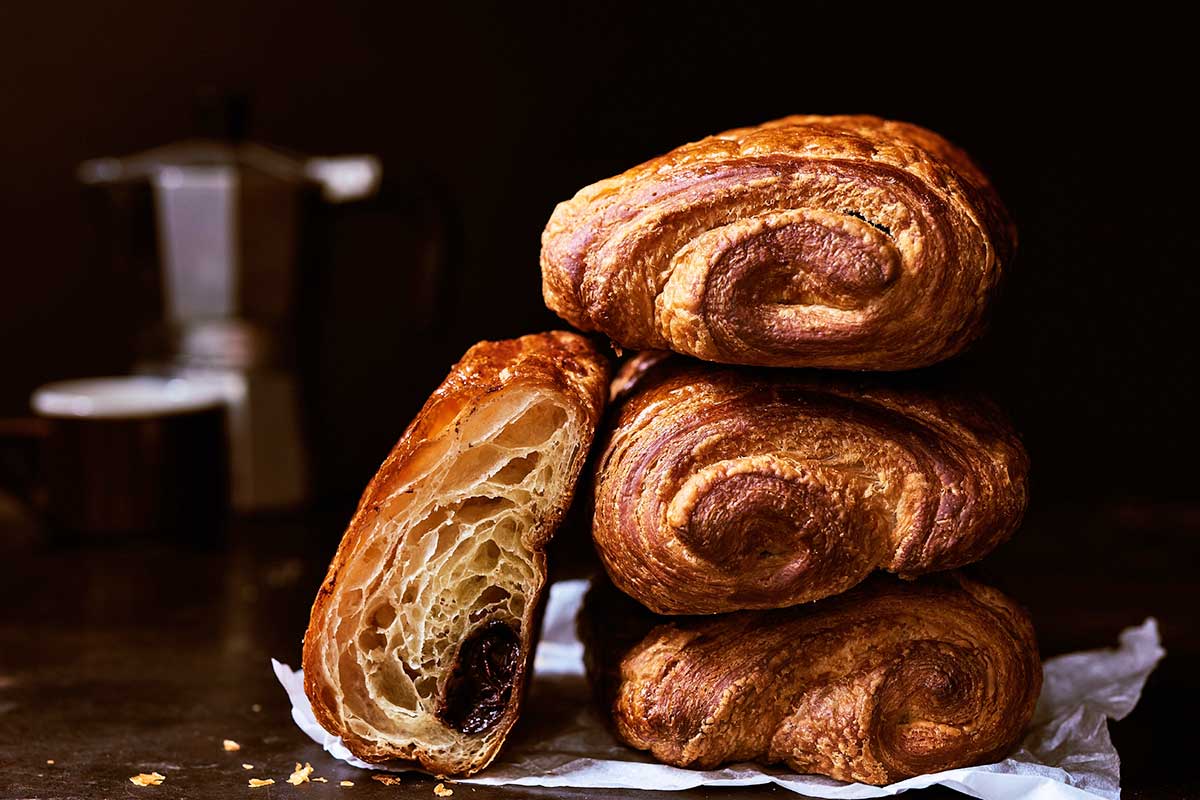 Stack of pain au chocolat, with one sliced in half to show its layers