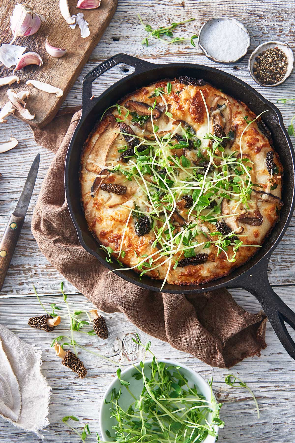 Crispy cheesy pan pizza with wild mushrooms, Fontina cheese, and pea shoots