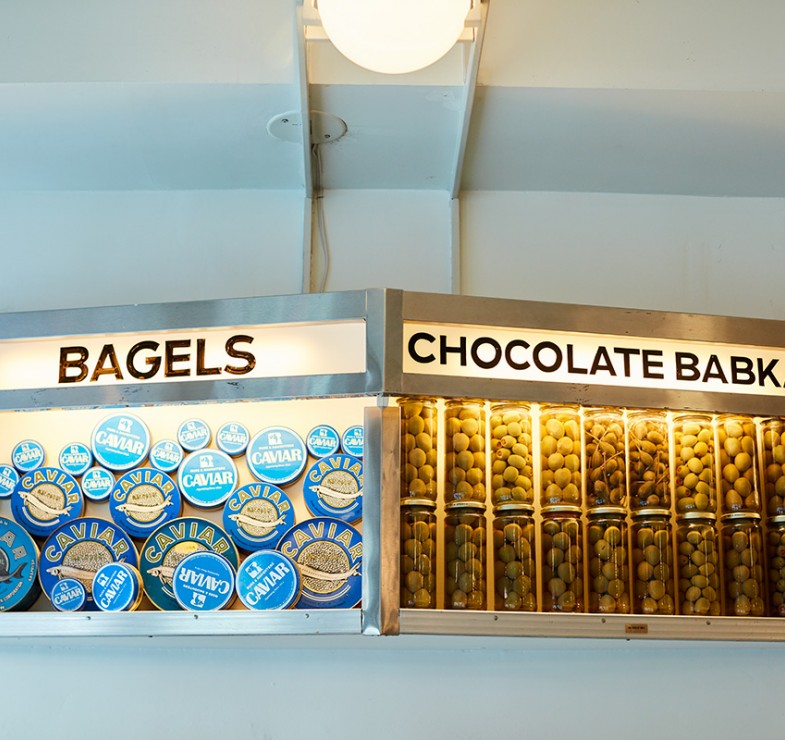 Russ and Daughters display case containing caviar tins and jars of olives