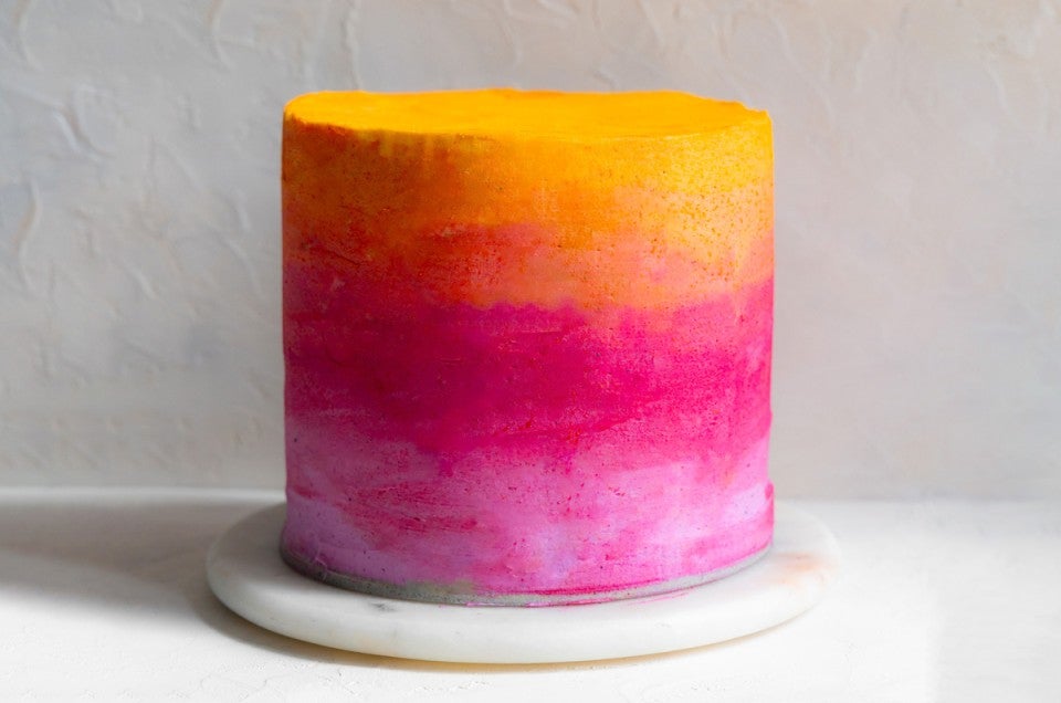 Ombre cake colored with yellow, orange, pink, and purple frosting