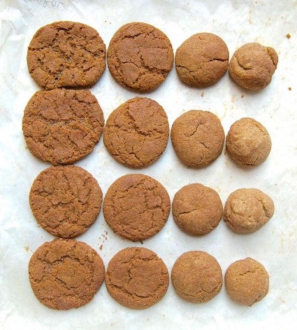 Four rows of cookies showing the results of reducing sugar in the dough: the ess sugar in the dough, the less the cookies spread and the lighter colored they are.