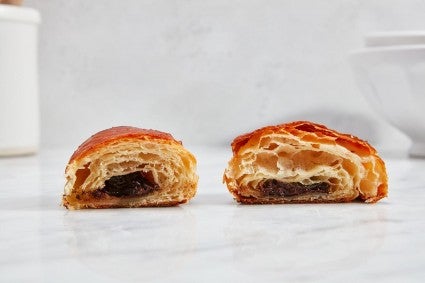 Two pain au chocolat side by side, cut into to show the structure