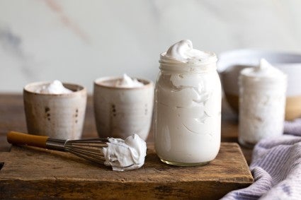 Homemade marshmallow spread spooned into an assortment of jars and glasses.
