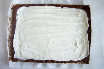 Unrolled cake with whipped cream filling spread on top