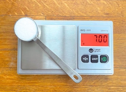 Micro scale with a teaspoon of salt placed on the weighing plate.