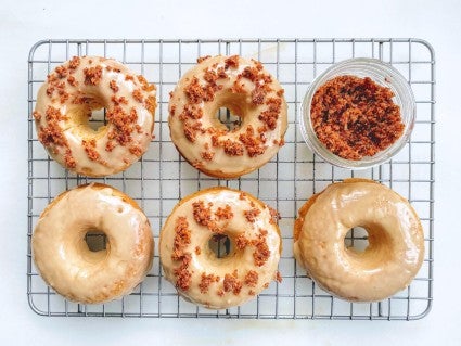 Maple-bacon baked doughnuts glazed with maple icing and sprinkled with crumbled candied bacon.