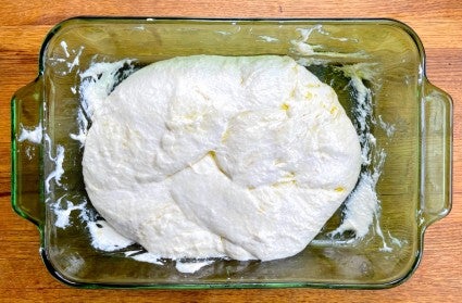Very slack dough for sourdough Pan de Cristal in a green glass shallow casserole dish